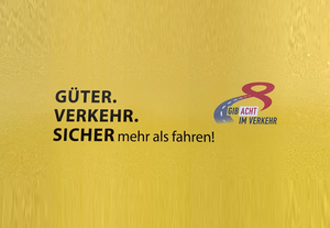 Gelbes Plakat mit „Güter. Verkehr. Sicher.“ und dem Logo „Gib Acht im Verkehr“.