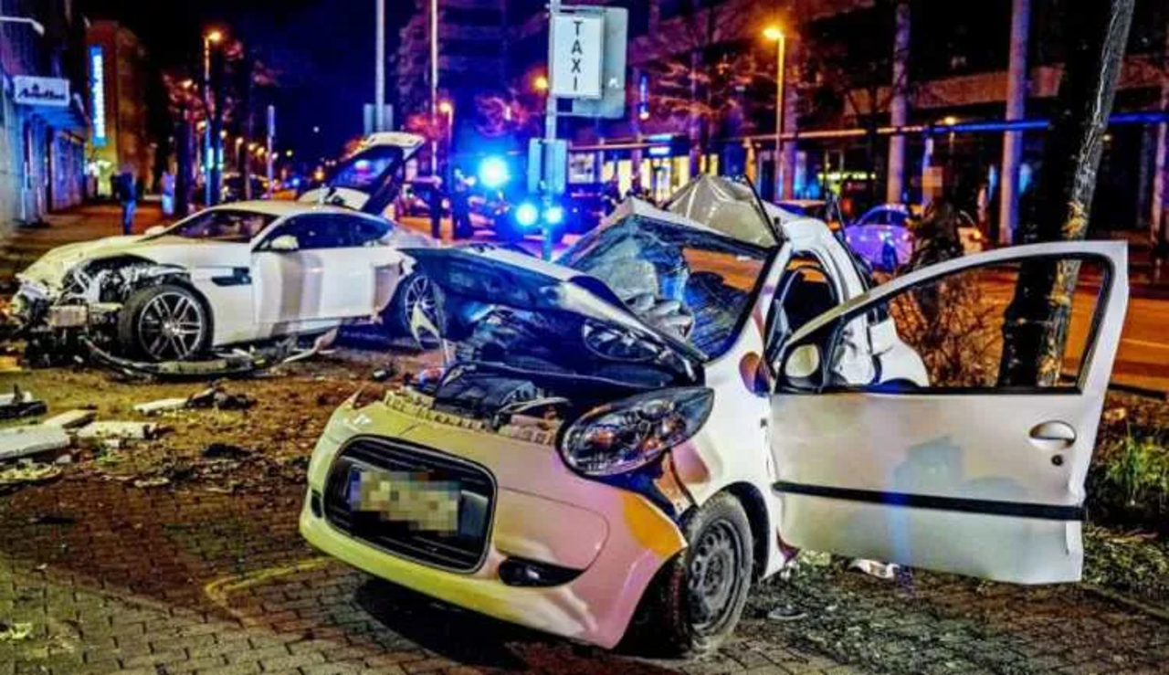 weißer verunfallter Kleinwagen; dahinter ein verunfallter Sportwagen 