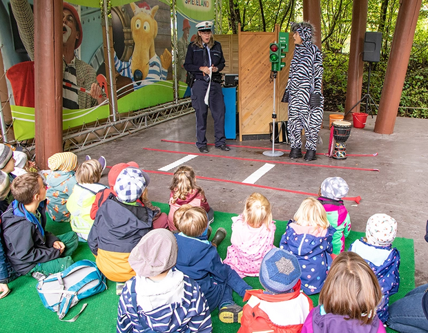 Polizist erklärt Zebra die Ampel-Kindergruppe schaut zu